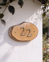 A Number 22 Natural Hard Wood Rustic House Number Sign Mounted on a White Coloured Cottage Wall - Digital Illustration A Number 22 Natural Hard Wood Rustic House Number Sign Mounted on a White Coloured Cottage Wall - Digital Illustration