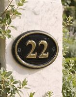 A Number 22 Polished Brass & Black Oval House Number Sign Mounted on a Cream Coloured Property Wall - Digital Illustration A Number 22 Polished Brass & Black Oval House Number Sign Mounted on a Cream Coloured Property Wall - Digital Illustration
