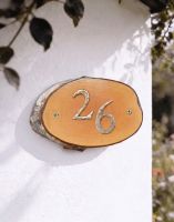 A Number 26 Natural Hard Wood Rustic House Number Sign Mounted on a Sunny Garden Cottage Wall - Digital Illustration