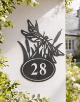 A Number 28 Dragonfly Iron House Number Sign Mounted on a Sunny White Cottage Wall- Digital Illustration 