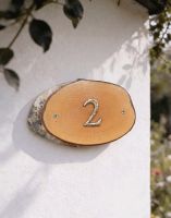 A Number 2 Natural Hard Wood Rustic House Number Sign Mounted on a Cream White Cottage Wall - Digital Illustration