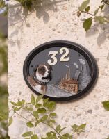 A Number 32 Staffordshire Bull Terrier House Number Sign in a Hand Painted Finish Mounted on a Cream Coloured Cottage Wall - Digital Illustration
