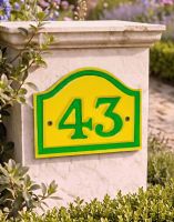 A Number 43 Yellow and Green Painted Arched House Number Sign Mounted on an Entrance Driveway Wall - Digital Illustration 