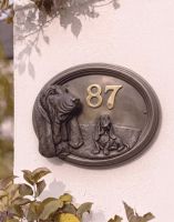 A Number 87 Basset Hound House Number Sign in a Bronze Finish Mounted on a Cream Coloured Cottage Wall - Digital Illustration