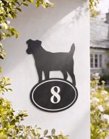 A Number 8 Jack Russell Iron House Number Sign Mounted on a White Garden Wall in Front of a Country Home - Digital Illustration