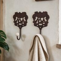 A pair of "Royal Camelot" Cast Iron Hooks Fitted onto a White Wall in a Traditional Home - Digital Illustration