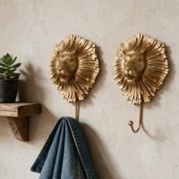 A Pair of Artistic Gold Lion Hooks Pictured on a Will Lit Interior Wall in a Modern Home - Digital Illustration 