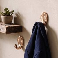 A Pair of Polished Bronze Single Pronged Coat Hooks in a Sunny Corridor in a Modern Home - Digital Illustration A Pair of Polished Bronze Single Pronged Coat Hooks in a Sunny Corridor in a Modern Home - Digital Illustration