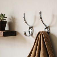 A Pair of “Rewfort Bridge” Bright Chrome Coat & Hat Hooks Next to a Timber Shelf in a Country Home - Digital Illustration 