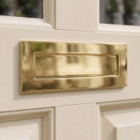 A Polished Brass Large Traditional Letter Plate Fixed to a Sunny Front Door of a Home - Digital Illustration