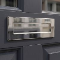 A Polished Nickel Large Traditional Letter Plate on the Front of a Wooden Front Door - Digital Illustration