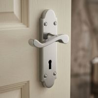 A Satin Chrome Victorian Scroll Latch Arched Keyhole Door Handle on a Cream Door in a Country Home - Digital Illustration