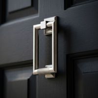 A Satin Stainless Steel Modern Knurled Rectangular Door Knocker Mounted onto a Black Coloured Wooden Front Door - Digital Illustration A Satin Stainless Steel Modern Knurled Rectangular Door Knocker Mounted onto a Black Coloured Wooden Front Door - Digital Illustration