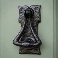 A Traditional Cast Iron Door Knocker on a Sage Green Front Door - Digital Illustration