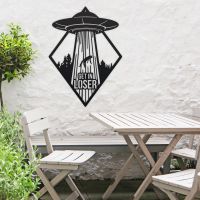 "Get in Loser" Alien Wall Art in Situ by a Wooden Table Set in the Garden