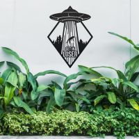 "Get in Loser" Alien Wall Art Above a Bush Outdoors