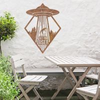 "Get in Loser" Alien Wall Art in Situ by a Wooden Table Set in the Garden