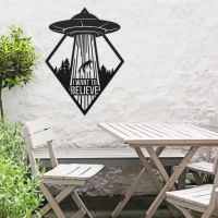 "I Want to Believe" Alien Wall Art in Situ by a Wooden Table Set in the Garden