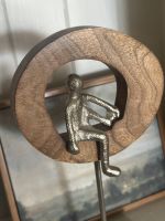 Angled close up of silver figure on home decor ornament