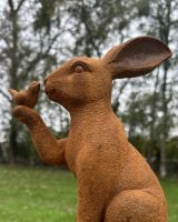Angled close up of rabbit and bird rustic finish garden sculpture