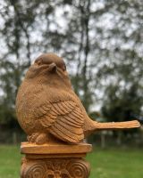 Angled close up of intricate robin detail on cast iron garden ornament