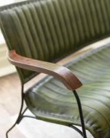 Close up of mango wood armrest on olive sofa