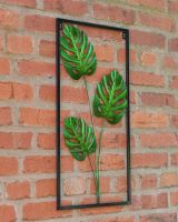 Angled view of monstera leaf wall art