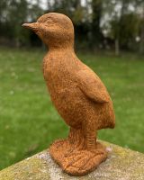Angled view of rustic finish duckling garden sculpture