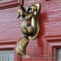 Antique Brass Squirrel door knocker on red door Antique Brass Squirrel door knocker on red door