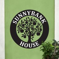 Circular House Name Sign on Green Wall 