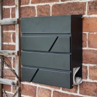"Arlington" Black Modern Wall Mounted Post Box on the Front of a House holding a Newspaper