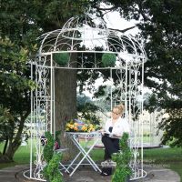 Iron ornate scroll gazebo in garden Iron ornate scroll gazebo in garden