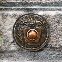 Burnished Copper Lion face bell push on brick wall Burnished Copper Lion face bell push on brick wall