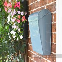 Modern letter box on wall in garden