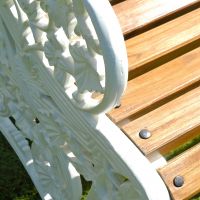 Detailed image of arm rest and wooden slats on cast iron bench