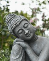 Close up of face detail on stone effect buddha outdoor statue Close up of face detail on stone effect buddha outdoor statue