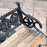 Close up of view of Aged Black Cast Iron Bench with wooden slats