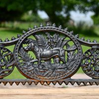 Close up of central motif with dog in aged black cast iron