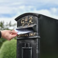 Close-Up of Letter Opening in Use on Freestanding Black Post Box