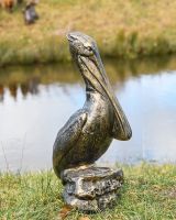 Brushed Gold Pelican Garden Sculpture on Display by the Water
