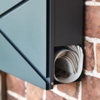 Close-Up of Newspaper Holder on Wall Mounted Post box