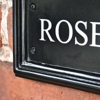 Close-up of the hite Vinyl Lettering on the Black Traditional House Name Sign