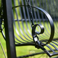 Blacksmith hand forged scroll work arm rest on garden swing bench