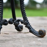 Close up of scroll feet on Victorian Aged Black Cast Iron Side Table