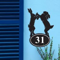 Boxing Hares Iron House Number Sign in Situ on a Blue Wall