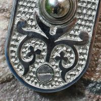 Close up of ornate pattern on door push button