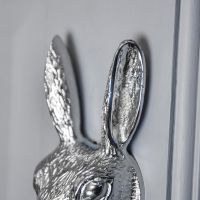Close-Up of Rabbit Ears on Bright Chrome Door Knocker