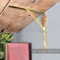 Polished Brass Gallows Bracket Holding Up a Wooden Shelf Polished Brass Gallows Bracket Holding Up a Wooden Shelf