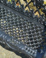 Close up of intricate seat detailing on black outdoor bench
