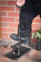 Black ornate boot scraper in use